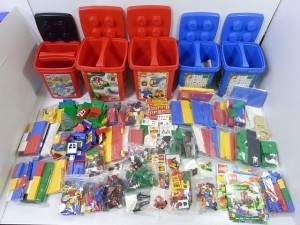 カラフルなレゴが並んでいる。赤や青のバケツや、沢山のLEGOブロックやフィグがある。