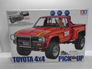    TAMIYA 1/10 トヨタ　ハイラックス　4WDの箱。赤い車体や、ドライバーの運転している姿のイラストが書かれている。