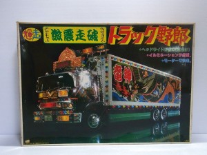  バンダイ 1/32 トラック野郎 激震走破の箱。光が反射する様子や、電飾、ボディのペイントなどが描かれている。